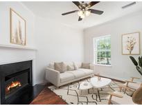 Bright living room featuring a fireplace, ceiling fan, neutral paint, and a large window for natural light at 277 Ralph David Abernathy Sw Blvd, Atlanta, GA 30312