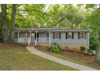 Charming one-story home featuring a welcoming front porch and professionally landscaped front yard at 3521 Brookhill Cir, Marietta, GA 30062