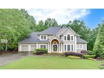 Charming two-story home featuring a three-car garage and a well-manicured front lawn at 3028 Towneside Ln, Woodstock, GA 30189