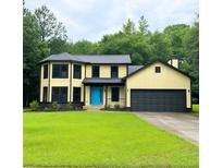 Two-story home with bright blue door and well-manicured lawn at 2615 Fox Hall South Ln, Atlanta, GA 30349
