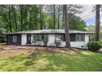 Charming renovated single-story brick home with a well-manicured lawn, set amongst mature trees at 2975 Rollingwood Se Ln, Atlanta, GA 30316
