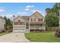 Charming two-story home with a welcoming front porch, attached two-car garage, and landscaped yard at 113 Westchester Xing, Canton, GA 30115