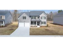 Charming two-story home with a two car garage, manicured lawn, and a symmetrical design at 1149 Blue Juniper Cir, Loganville, GA 30052