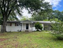 Ranch-style home featuring a white brick exterior, covered entrance, and lush greenery at 1066 Cleavemark Dr, Clarkston, GA 30021