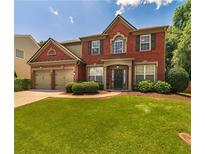 Charming two-story brick home with a well-manicured lawn and attached two-car garage at 939 Bendleton Dr, Woodstock, GA 30188