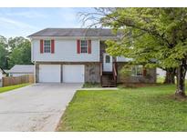 Charming two-story home with a two-car garage and stone accents and front lawn at 946 Redan Trce, Stone Mountain, GA 30088