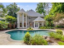 Backyard with a beautiful pool surrounded by a stone patio and lush landscaping at 1078 Shady Valley Ne Pl, Atlanta, GA 30324