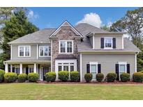 Charming two-story home with stone accents, a welcoming front porch, manicured lawn, and lush landscaping at 1501 Laurelhill Drive Southwest Dr, Lawrenceville, GA 30044