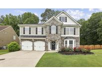 Charming two-story home with stone accents, manicured lawn, and a two-car garage at 3395 The Commons Dr, Cumming, GA 30041