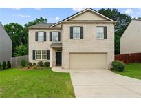 Charming two-story home with a brick facade, well-manicured lawn, and an attached two-car garage at 105 Arbor Creek Trl, Dallas, GA 30157