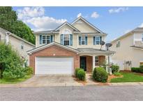 Charming two-story home with a brick facade, attached garage, inviting front porch, and manicured landscaping at 3698 Roseman Lndg, Cumming, GA 30040