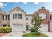 Charming townhome with a one-car garage, blue shutters, neutral siding, and manicured landscaping at 768 Nehemiah Sw Ln, Atlanta, GA 30331