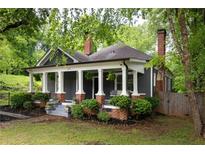 Charming home featuring a beautiful gray exterior, brick accents, and a welcoming front porch with stylish columns at 230 Milton Se Ave, Atlanta, GA 30315