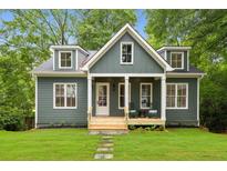 Charming exterior view of a two-story home with a manicured lawn and inviting front porch at 2760 Fraser Se St, Smyrna, GA 30080
