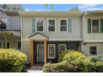 Charming townhome featuring light siding, blue shutters, a covered entryway, and well-maintained landscaping at 657 Stratford Green Way, Avondale Estates, GA 30002