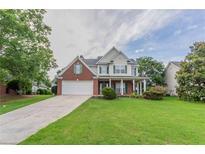 Charming two-story home with a brick facade, white siding, and a well-manicured lawn at 806 Chelsea Wood Ct, Stockbridge, GA 30281