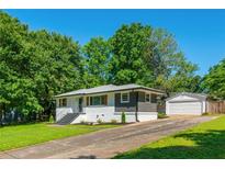 Charming single-story home with a well-maintained lawn, painted brick and a detached garage at 941 Shirley Se St, Smyrna, GA 30082