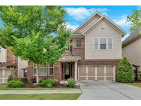 Charming two-story home featuring brick and siding, a well-manicured lawn, and an attached two-car garage at 12 Pine St, Roswell, GA 30075