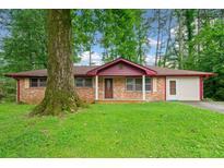 Charming brick home with a well-manicured front yard and mature shade trees at 3047 Hudson Ct, Decatur, GA 30033