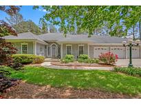 Charming single-story home featuring manicured landscaping, a three-car garage, and a welcoming entrance at 3140 Thoreau Ct, Loganville, GA 30052