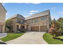 A beautiful brick two-story home with a curved driveway and an attached two-car garage at 3834 Chamblee Dunwoody Rd, Atlanta, GA 30341
