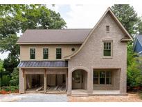 Stunning new construction featuring a gray brick exterior, covered porch, and an attached two-car garage at 1115 Ralph Ne Rd, Atlanta, GA 30324