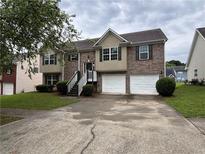 Charming two-story home featuring a brick facade, attached two-car garage, and inviting front steps at 4069 Savannah Ridge Ct, Loganville, GA 30052