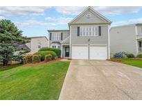 Charming two-story home with a well-manicured lawn and a two-car garage at 626 Dahoma Trail Trl, Woodstock, GA 30188