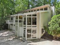 Unique modern home featuring expansive windows and a two-car garage with a fenced-in yard at 405 Forest Valley Road, Sandy Springs, GA 30342