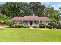Beautifully landscaped front yard with lush green lawn and mature trees at 621 Windgrove Se Rd, Marietta, GA 30067