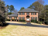 Traditional two-story brick home with black shutters and a well-manicured front lawn at 938 Lost Valley Se Dr, Conyers, GA 30094