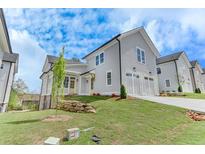 Charming home featuring a two-car garage, inviting facade, and landscaped front yard at 1294 Six Sisters St, Dacula, GA 30019