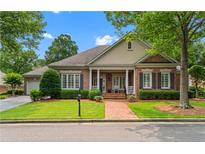 Charming brick home featuring a manicured front yard and inviting covered porch with stately columns at 2117 Stephens Walk, Dunwoody, GA 30338