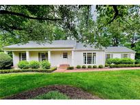 Charming single-story home featuring a manicured lawn, brick walkway, and lush landscaping at 380 Lamplighter Se Ln, Marietta, GA 30067