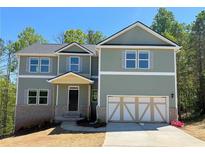 Charming two-story home featuring a light green exterior, gray shutters, and a two-car garage at 66 Pine Creek Ct, Dallas, GA 30157