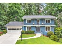 Charming two-story home featuring a blue exterior, a well-manicured lawn, and an attached two-car garage at 2210 Chrysler Ne Ter, Atlanta, GA 30345