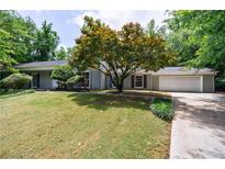 Charming single-story home with a lush front yard and mature landscaping at 135 Pheasant Se Dr, Marietta, GA 30067