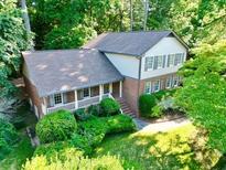 Charming home with a manicured lawn and inviting front porch, surrounded by lush trees at 7310 Ne Wynhill Ne Dr, Atlanta, GA 30328