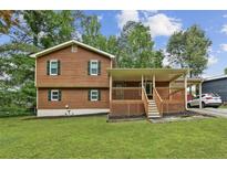 Charming two-story home featuring wood siding, a covered porch and a well-manicured lawn at 860 The Cir, Lawrenceville, GA 30043
