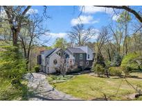 Charming home with mature trees, a winding driveway, and professionally landscaped front yard at 10845 Shallowford Rd, Roswell, GA 30075