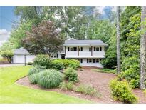 Charming two-story home featuring landscaped front yard, complemented by trees for added shade at 1329 W Nancy Creek Ne Dr, Brookhaven, GA 30319