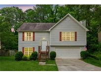 Charming two-story home featuring a well-manicured lawn, attached garage, and inviting entrance at 5519 Princeton Oaks Ln, Sugar Hill, GA 30518