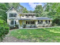 Charming two-story home with a well-manicured lawn and mature trees offering curb appeal at 10035 Anaheim Dr, Alpharetta, GA 30022