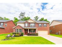 Charming brick two-story home with an attached garage and well-manicured landscaping at 12275 Styron Dr, Hampton, GA 30228