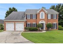 Traditional brick home with a two-car garage, manicured lawn, and mature landscaping at 505 Stedford Lane, Duluth, GA 30097