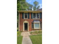 Charming brick home featuring dark green shutters and lush lawn at 932 Chippendale Ln, Norcross, GA 30093