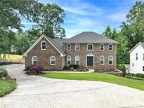 Stunning brick home featuring a meticulously landscaped yard and an extended driveway at 10300 Carleigh Ln, Roswell, GA 30076