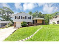 Charming split-level home featuring well-maintained lawn, driveway and classic architectural details at 2767 Kathie Ln, Ellenwood, GA 30294