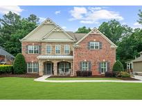 Stunning two-story brick home with a meticulously manicured lawn and inviting curb appeal at 4435 Manor Creek Dr, Cumming, GA 30040