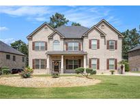 Stunning two-story brick home with a well-manicured lawn and lovely landscaping in a desirable neighborhood at 6861 Louis Dr, Locust Grove, GA 30248